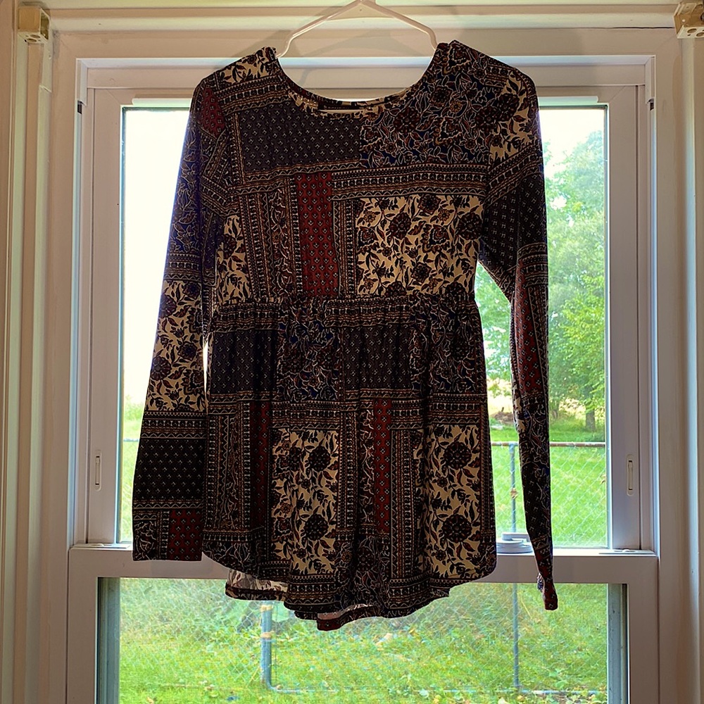 Small long sleeve top with different colors and patterns.